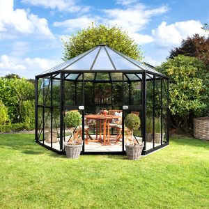 Stylish black metal and glass greenhouse set in a lush garden, perfect for growing plants, vegetables, and flowers, offering optimal conditions with durable construction.